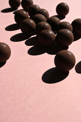 spherical chocolates with strong shade on a pink background