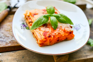   Delicious Home made keto diet  Lasagna bolognese  with  Lupin Flour, minced meat,tomato sauce and spinach  on a wooden rustic  background.Home made low carb italian meal