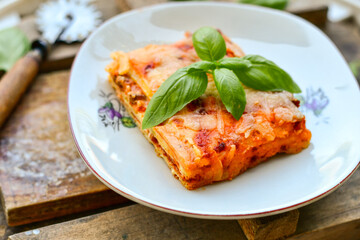   Delicious Home made keto diet  Lasagna bolognese  with  Lupin Flour, minced meat,tomato sauce and spinach  on a wooden rustic  background.Home made low carb italian meal