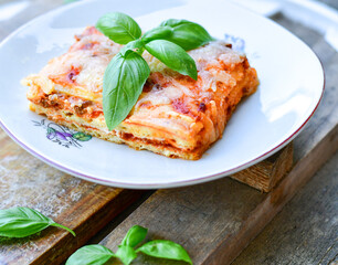   Delicious Home made keto diet  Lasagna bolognese  with  Lupin Flour, minced meat,tomato sauce and spinach  on a wooden rustic  background.Home made low carb italian meal