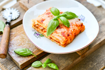   Delicious Home made keto diet  Lasagna bolognese  with  Lupin Flour, minced meat,tomato sauce and spinach  on a wooden rustic  background.Home made low carb italian meal