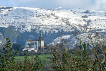 Fototapeta na wymiar Church of San Esteban de Galdames with the snowy mountains in the background