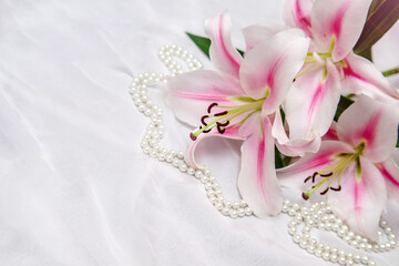 The branch of white lilys on white fabric background
