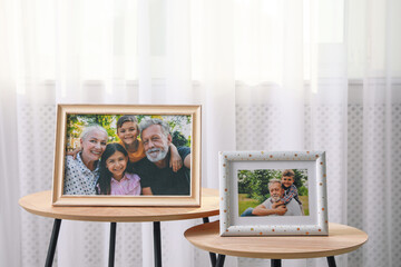 Framed family portraits near window in room