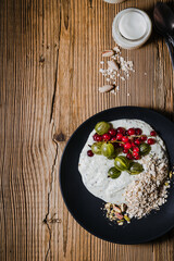 Breakfast smoothie bowl with gooseberries, red currants, rolled oats, pistachios