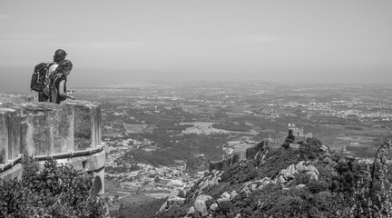 A couple at Pena Palace enjoying the magnificent top view of Castle of Moors and Portuguese landscape from afar - Portugal, Sintra - Black and white, 28.05.2021
