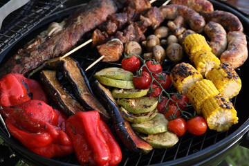 Tasty meat and vegetables on barbecue grill, closeup