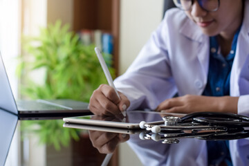 Doctor use digital tablet and work on laptop computer.