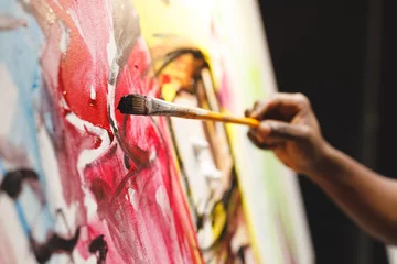 Foto op Plexiglas Close up of african american male painter at work painting on canvas in art studio © wavebreak3