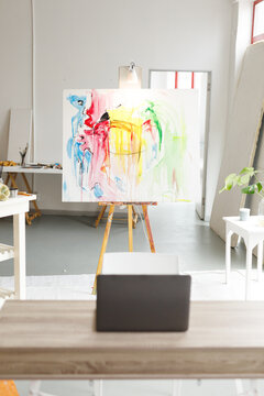 Modern abstract oil painting on canvas sitting on easel in artists studio