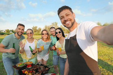 Happy friends with drinks taking selfie at barbecue party in park - Powered by Adobe