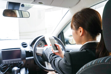 営業車で電話をするキャリアウーマン