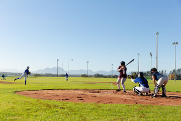 Diverse group of female baseball players in action on sunny baseball field during game