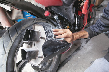Preparation for painting a motorcycle. Hand in a sandpaper