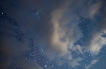 Starry sky and long exposhur clouds. Dark night sky with clouds. Astronomical background.