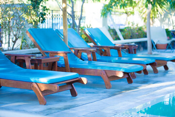 Sun loungers by the pool with water next to the hotel