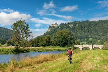 Fototapeta na wymiar beautiful active senior woman cycling with her electric mountain bike in the rocky Upper Danube Valley on the Swabian Alb between Beuron and Sigmaringen