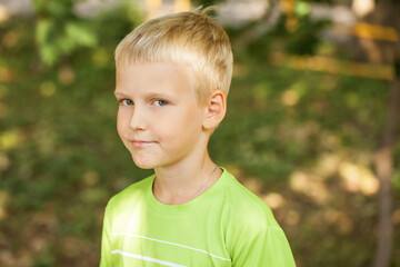 Blonde little boy in a summer park