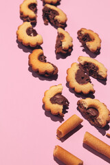 Biscuit cookies half on pink background. Flat lay scene. Minimal art. Holidays time, present,  winter christmas celebration stylish wallpaper