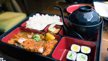 Pork katsu curry bento box serve with miso soup.