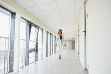 Fototapeta premium Young Businesswoman Standing In Corridor Of Modern Office Building