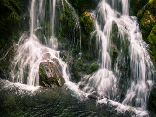 Fototapeta na wymiar Detalle de una cascada de un rio de alta montaña que rompe sobre una gran roca