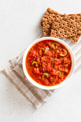 Matbucha - Moroccan Tomato dip. Sauce of tomato, pepper, garlic and chili pepper in a bowl on a white background. Vegan food.