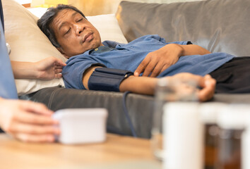Fototapeta premium Health visitor and a senior woman during home visit.Worried senior man talking to her general practitioner visiting her at home during virus epidemic.
