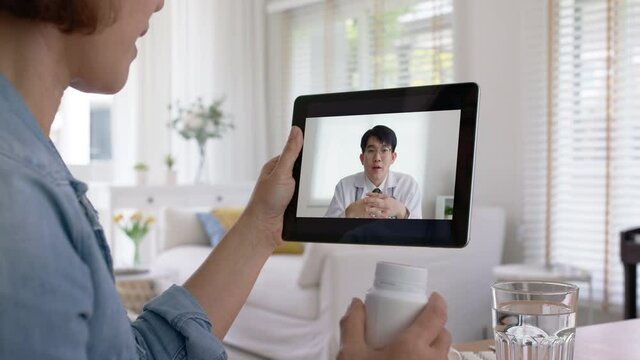 Close-up hand of asia sick people or young adult woman use remote call chat on health care clinic in covid self cure isolate recover drug pill teaching exam by VoIP telehealth telemedicine app help.