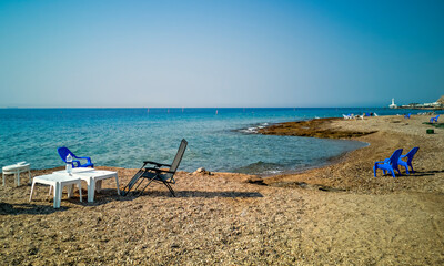 Sandy and sunny beach of the Red Sea with chairs for happy vacation and relaxation after travel...