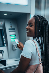 African american woman using credit card and atm machine