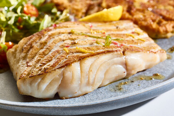 Freshly baked fish fillet served with mixed leaves
