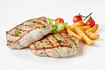 Delicious grilled fish served with French fries and cherry tomatoes