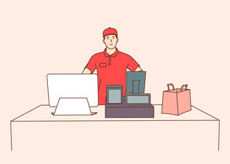 Young male employee cashier, worker using modern technology at workspace. Young smiling man cash register at the workplace in supermarket, shop.