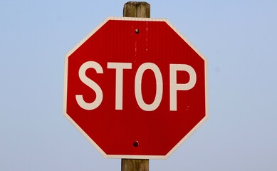 A close view of the stop sign with the blue sky background.