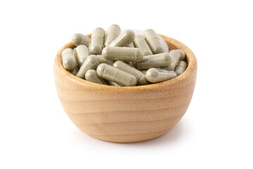 Andrographis paniculata capsule in wooden bowl isolated on white background, Medicine concept