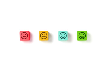 Emoticon faces in colors wooden blocks over white background. Service evaluation and satisfaction...