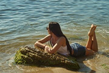 A happy young woman on the sea beach . Summer vacation .
