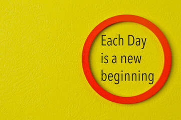 Phrase EACH DAY IS A NEW BEGINNING on yellow background. Motivational and inspirational concept.