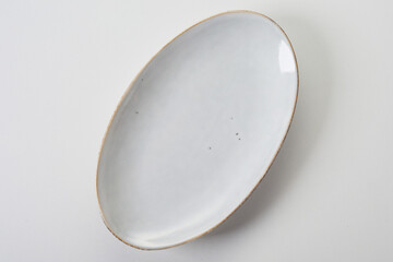 Oval shaped white ceramic plate with rim