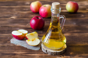 Apple vinegar in a glass bottle. Fermented Fruit Cider Organic Apples Wooden Background Side View Healthy Eating and Lifestyle Concept