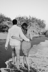 Portrait of Happy young European couple is walking along the beach. Happy life style. Black and white photo. High quality photo