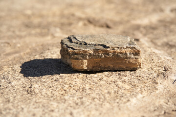 Stone podium on a beige background for a natural design concept. Central composition, front view. High quality photo