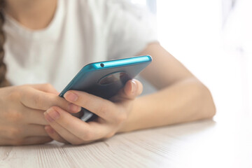 Close-up hand of woman using smartphone at coffee shop cafe, space for your text