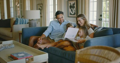 Happy young diverse family relaxing at home in the living room playing board games and reading book, family lifestyle - Powered by Adobe