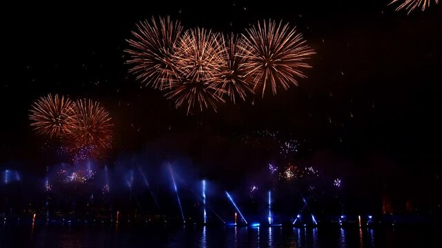 Festive colorful fireworks and illumination in dark sky with beautiful reflection in water. Holiday SCARLET SAILS. High quality photo
