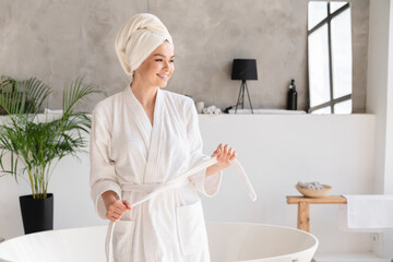 Young healthy serene woman girl relaxing in bathrobe and spa towel after having bath shower at home. Beauty treatment, rest and body care procedures.