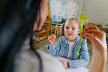 Girl on the session of speech therapist.