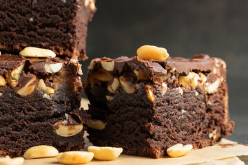 Cake in a close-up cut with nuts on a dark background, texture