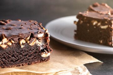 Chocolate cake in a close-up, nuts in chocolate on a dark background